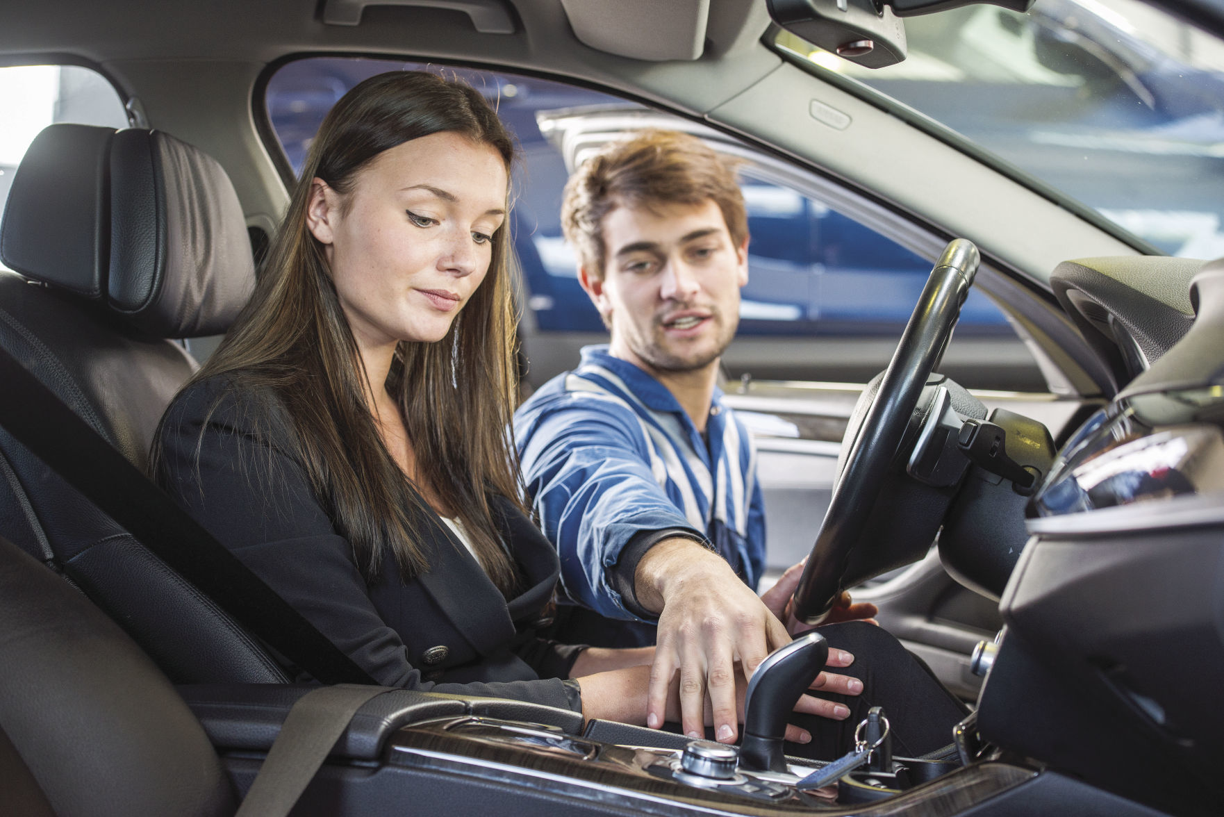 Mechanic demonstrating a second hand car to a potential customer